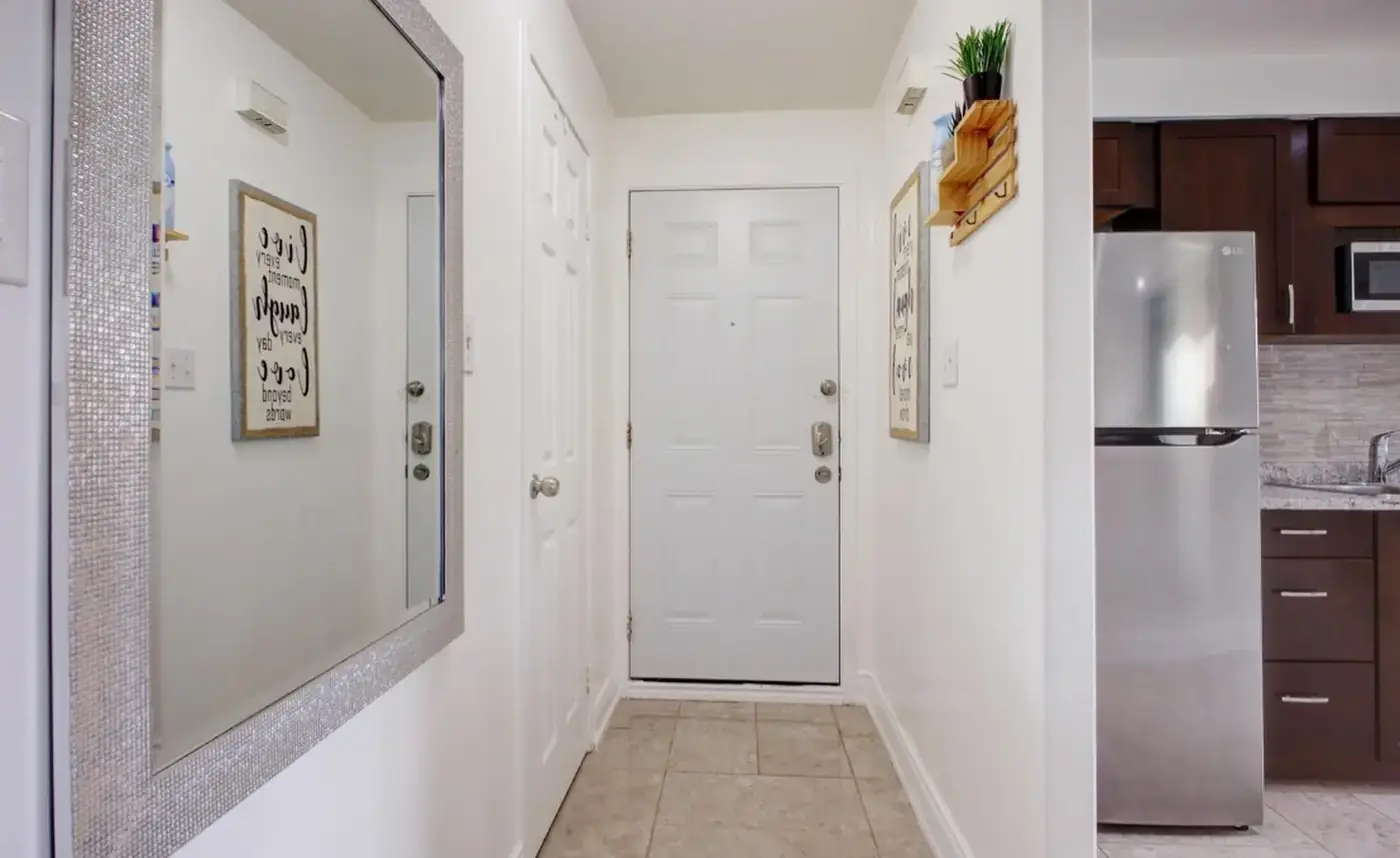Tiled front entry with a full-length mirror and coat closet