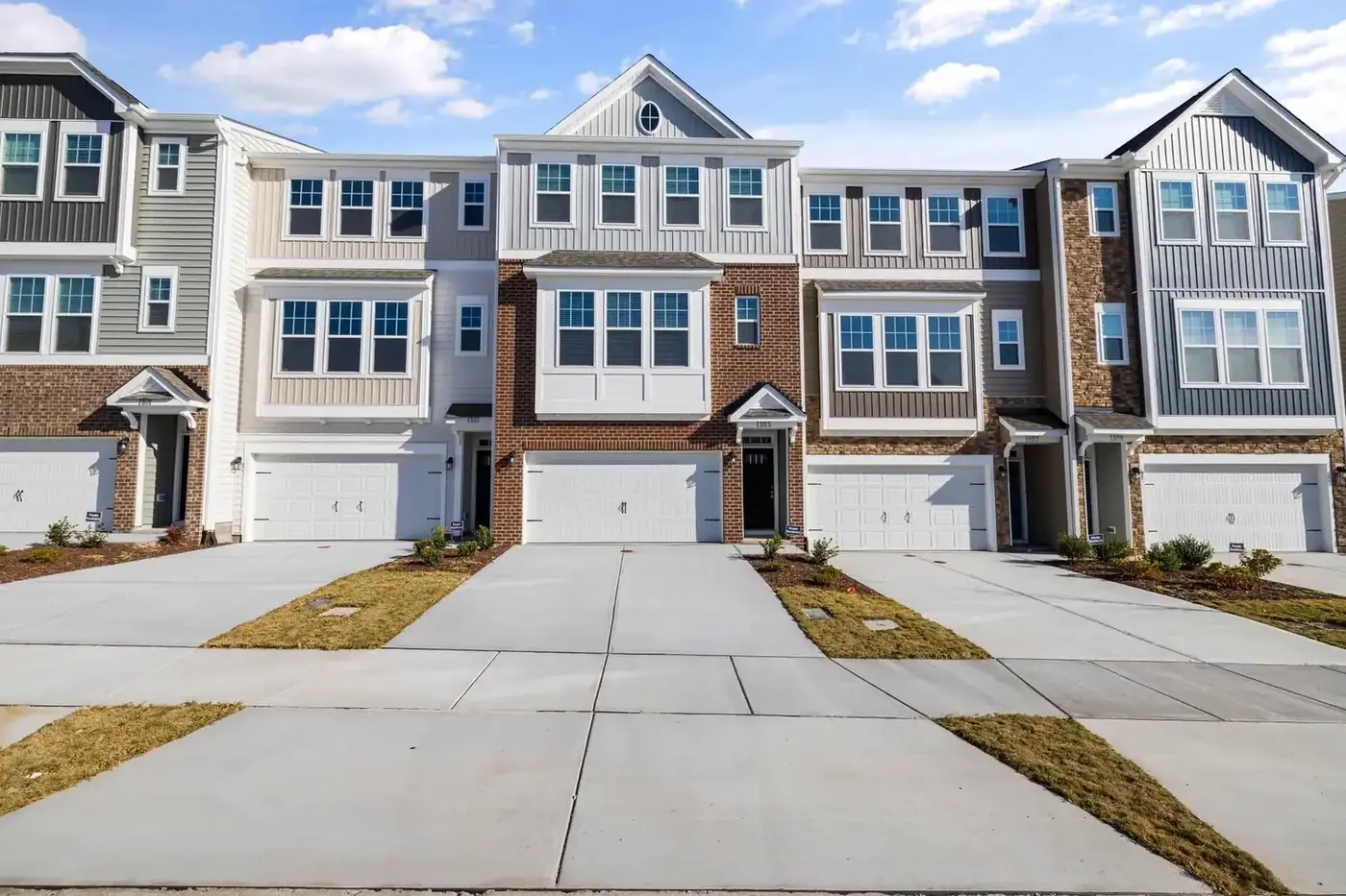 A row of modern townhouses with driveways and garages